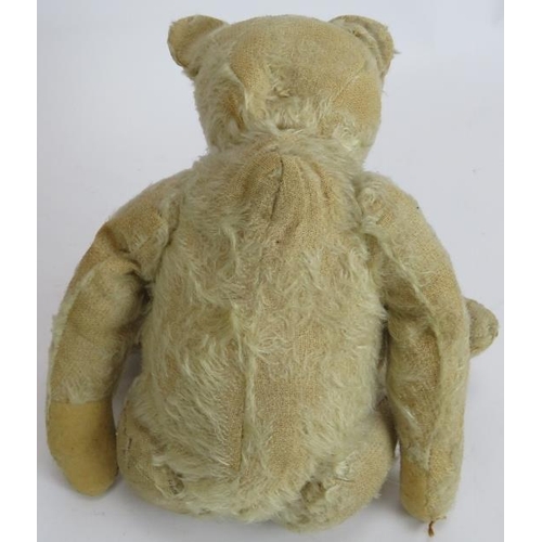 195 - An antique straw filled jointed teddy bear with long snout, hump back and jointed arms, legs and nec... 