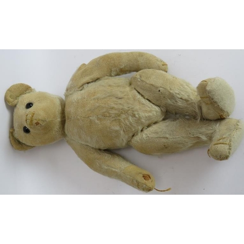 195 - An antique straw filled jointed teddy bear with long snout, hump back and jointed arms, legs and nec... 