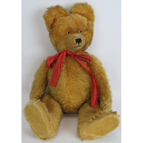 195 - An antique straw filled jointed teddy bear with long snout, hump back and jointed arms, legs and nec... 