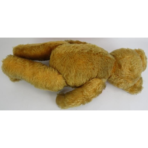 195 - An antique straw filled jointed teddy bear with long snout, hump back and jointed arms, legs and nec... 