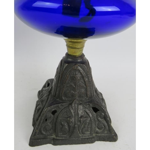 244 - A turn of the century cast iron based oil lamp with Bristol blue reservoir and etched glass shade. O... 