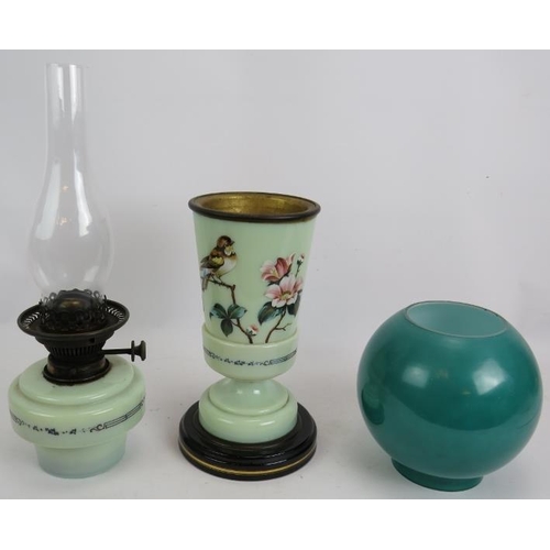 246 - An antique painted glass oil lamp hand decorated with flowers on a ceramic base and with green glass... 