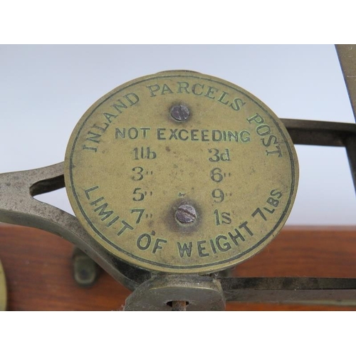 248 - A set of vintage English 7lb parcel postal scales mounted on an oak stand with weights. Height 23cm.... 