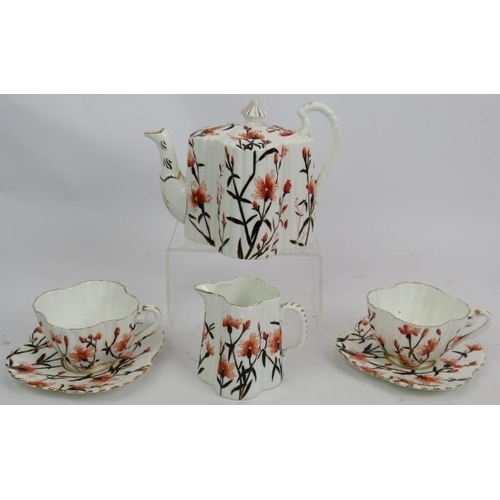 254 - Wileman & Co (Foley) pre Shelley fluted teapot, jug and two cups and saucers decorated with flowers.... 