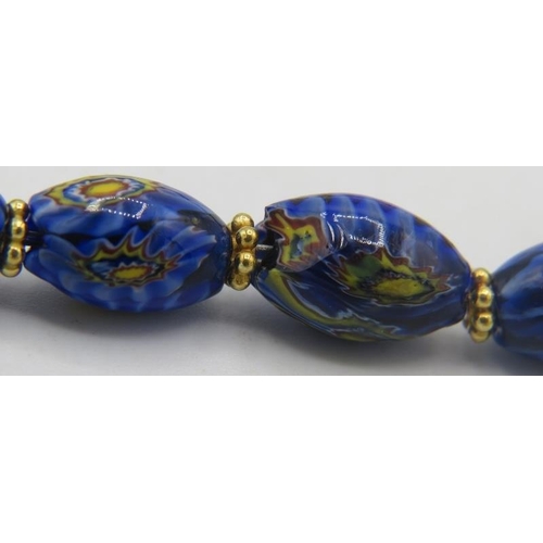 335 - A venetian milliflora blue glass bead necklace with yellow metal hook clasp and an amber style heart... 