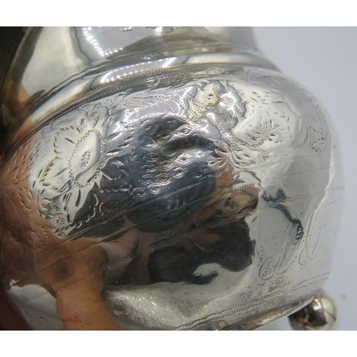 362 - A Georgian silver cream jug with engraved decoration, gilded interior and on ball feet. Hallmarks in... 