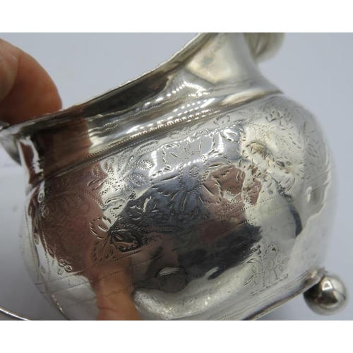 362 - A Georgian silver cream jug with engraved decoration, gilded interior and on ball feet. Hallmarks in... 