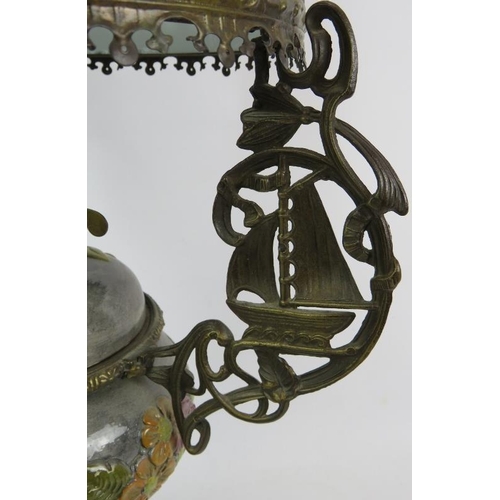 40 - A highly decorative oil lamp with relief moulded pottery reservoir cast brass stand and opaline glas... 