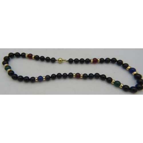 471 - A black onyx, lapis lazuli and cornelian necklace with 14 yellow metal spacers and on a 9ct yellow g... 