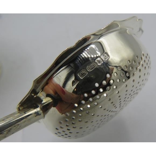 473 - A modern silver tea strainer with base. The tea strainer has a wooden handle, London 2003, J.A Campb... 