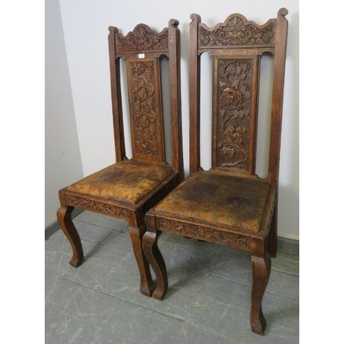 705 - A pair of 19th century Gothic revival oak hall chairs, the ornate relief carving depicting green man... 