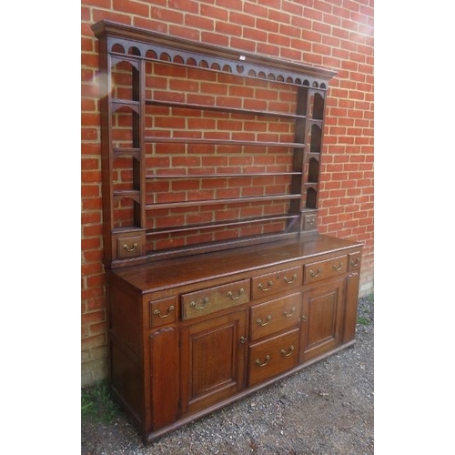 710 - An 18th century English oak dresser with plate-rack over a sideboard base, housing an array of drawe... 