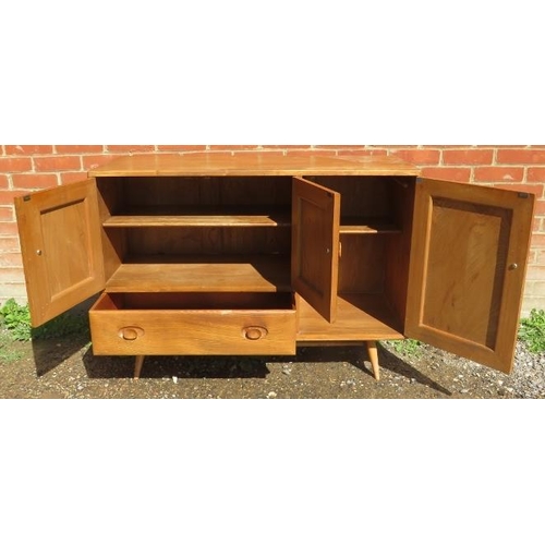 712 - A mid-century elm and beech sideboard by Ercol, housing two cupboards, both with loose shelves, and ... 