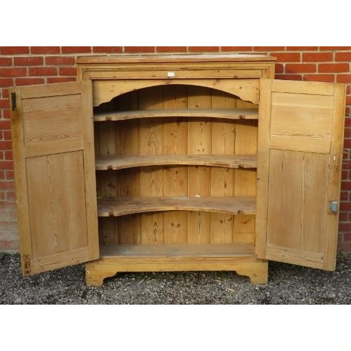 726 - An antique stripped pine pantry cupboard, the doors with fielded panels and cast-iron hinges, openin... 