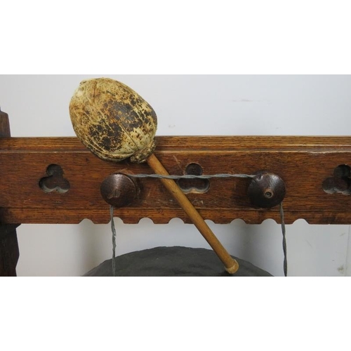 741 - A 19th century Gothic Revival bronze dinner gong, suspended in an oak frame featuring trefoil carved... 