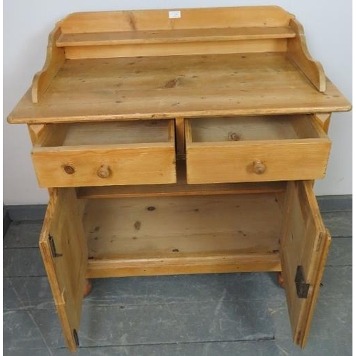 749 - An antique striped pine sideboard with shaped gallery, housing two short drawers and cupboard under ... 