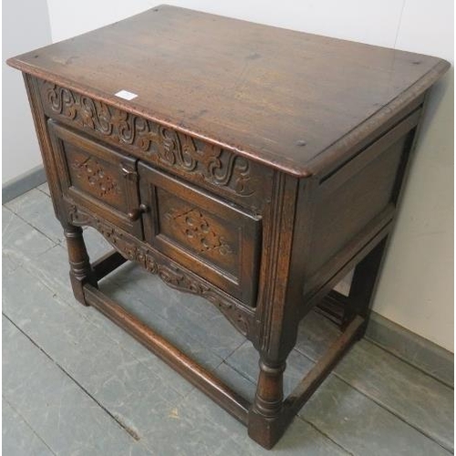 769 - An oak side cabinet in the 17th century taste, with relief carved frieze and twin doors with relief ... 