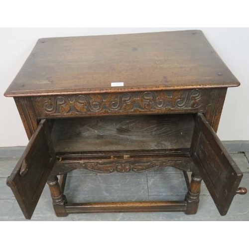 769 - An oak side cabinet in the 17th century taste, with relief carved frieze and twin doors with relief ... 