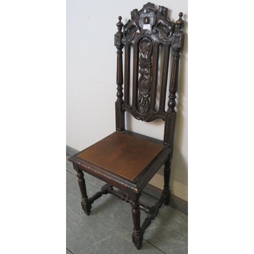 770 - A turn of the century oak hall chair, featuring carved and pierced back rest with heraldic crest dep... 