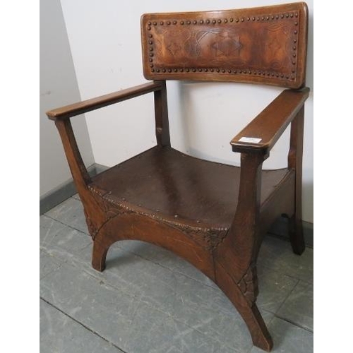 778 - An Arts & Crafts oak ‘X’ frame armchair with embossed leather back best and carved detail to legs. 
... 