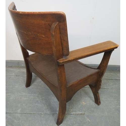 778 - An Arts & Crafts oak ‘X’ frame armchair with embossed leather back best and carved detail to legs. 
... 