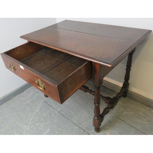 794 - An 18th century oak side table, the single drawer fitted with brass swan neck handles, on turned and... 