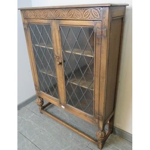 799 - A vintage oak glazed bookcase in the 17th century taste, the leaded doors opening onto two shelves, ... 