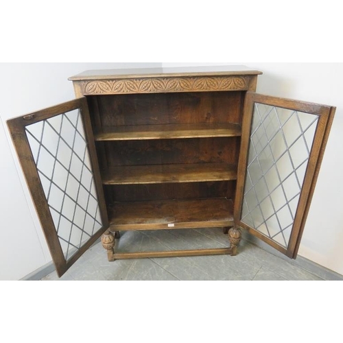 799 - A vintage oak glazed bookcase in the 17th century taste, the leaded doors opening onto two shelves, ... 