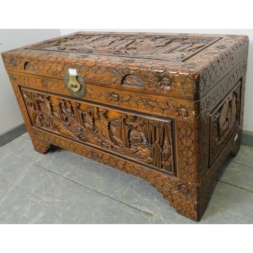 803 - A vintage Chinese export camphorwood trunk, with ornate relief carving depicting sailing junks and b... 