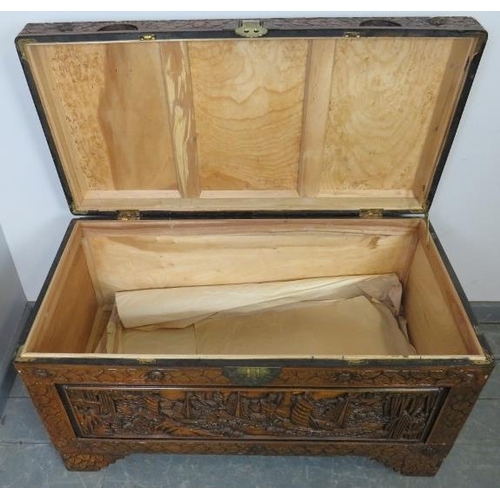 803 - A vintage Chinese export camphorwood trunk, with ornate relief carving depicting sailing junks and b... 