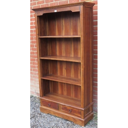 821 - A contemporary hardwood tall bookcase of three open shelves and two short drawers under, on a plinth... 