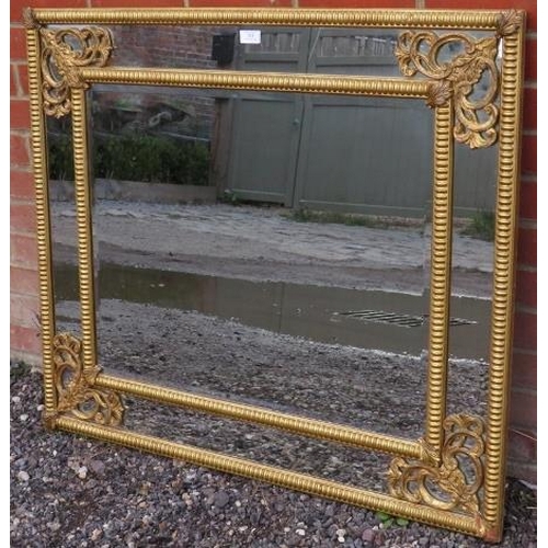 824 - A 19th century style cushion mirror with bevelled rectangular plate in a gilt gesso fretwork surroun... 