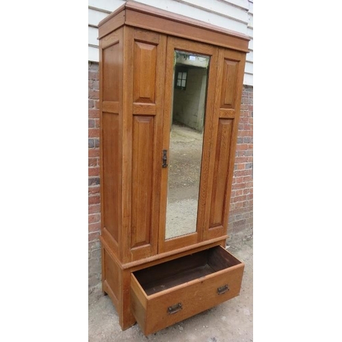 826 - An Edwardian light oak single wardrobe, with bevelled mirror door and fielded front panels, with one... 