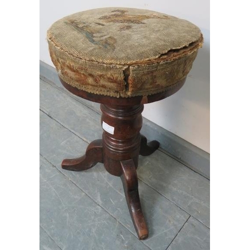 852 - A Victorian mahogany height adjustable music stool, retaining the original tapestry seat and horseha... 