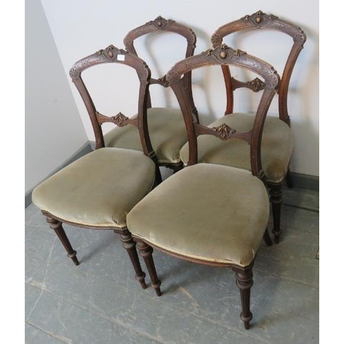 853 - A set of four Aesthetic Period mahogany balloon back dining chairs with carved backs, upholstered in... 