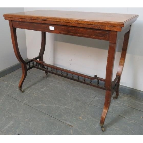 854 - An Edwardian rosewood turnover card table, strung with satinwood and featuring marquetry inlay, the ... 