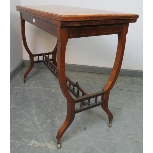 854 - An Edwardian rosewood turnover card table, strung with satinwood and featuring marquetry inlay, the ... 