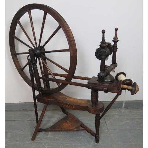 855 - A 19th century oak and mahogany pedal driven flax spinning wheel with turned finials. Includes two a... 