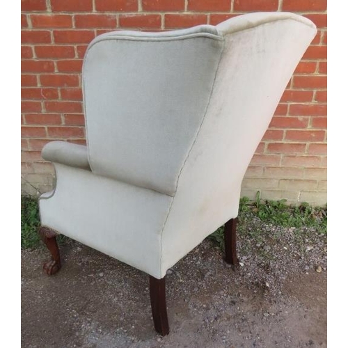 870 - A vintage Georgian style wingback armchair upholstered in a pale green draylon fabric raised on maho... 