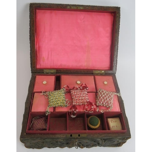 104 - A heavily embossed leather antique workbox with contents including pin cushions, scent bottle, greet... 