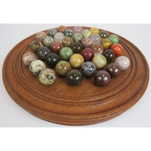 110 - A large turned wood solitaire board with full set of specimen stone marbles approx 28mm diameter. Bo... 