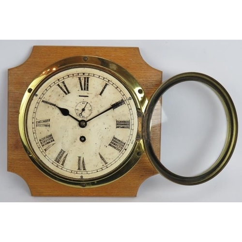 127 - An early 20th century brass cased ships clock on oak mount. Key present. Dial 20cm diameter.
Conditi... 