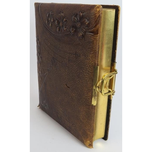 130 - A leather bound Victorian photo album with Art Nouveau decorated binding, gilt edges pages and gilt ... 