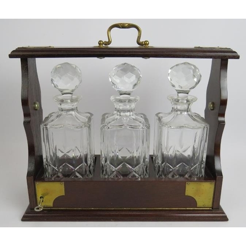 134 - A brass mounted mahogany three decanter tantalus with key.
Condition report: Slight staining interna... 