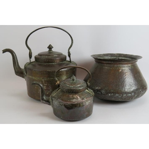 146 - Two beaten copper Omani kettles, largest 36cm tall and a similar beaten copper cooking pot, 32cm dia... 