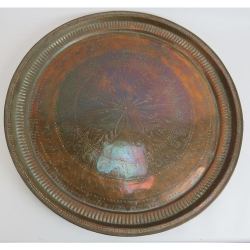 150 - Two large copper middle Eastern chargers, the largest signed to reverse, diameter 58cm, plus a coppe... 