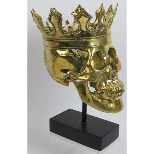 16 - A contemporary polished bronze model of a human skull wearing a crown mounted on a bespoke plinth. O... 