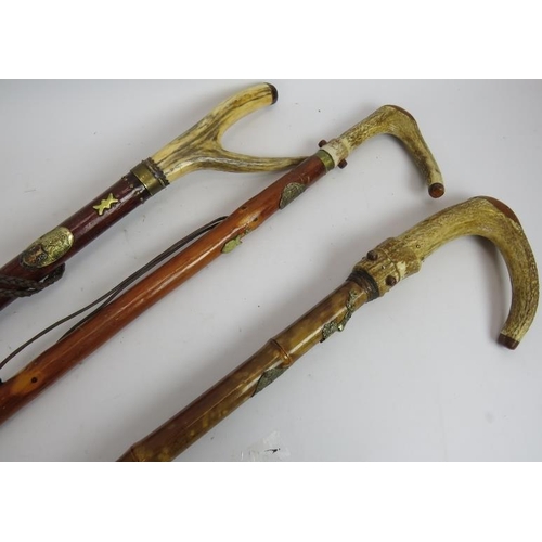 172 - Three hand crafted walking staffs, each with antler handles and decorated with Scottish metal plaque... 