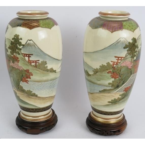 183 - A pair of finely decorated Japanese Satsuma vases with traditional Mount Fuji scenes standing on tur... 