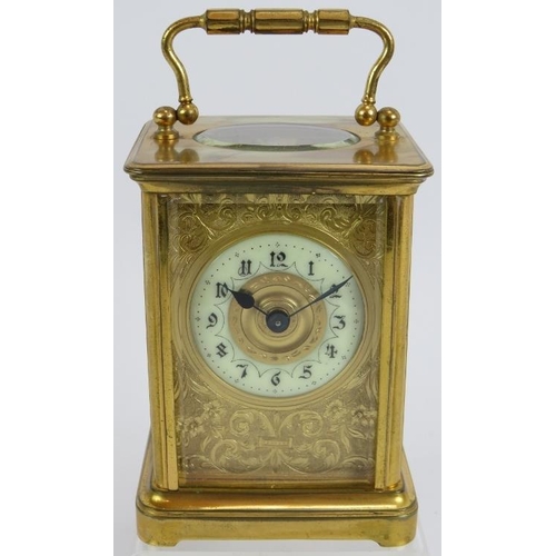 188 - A 19th century gilt brass cased carriage clock with engraved gilt mask and enamelled dial ting. Move... 